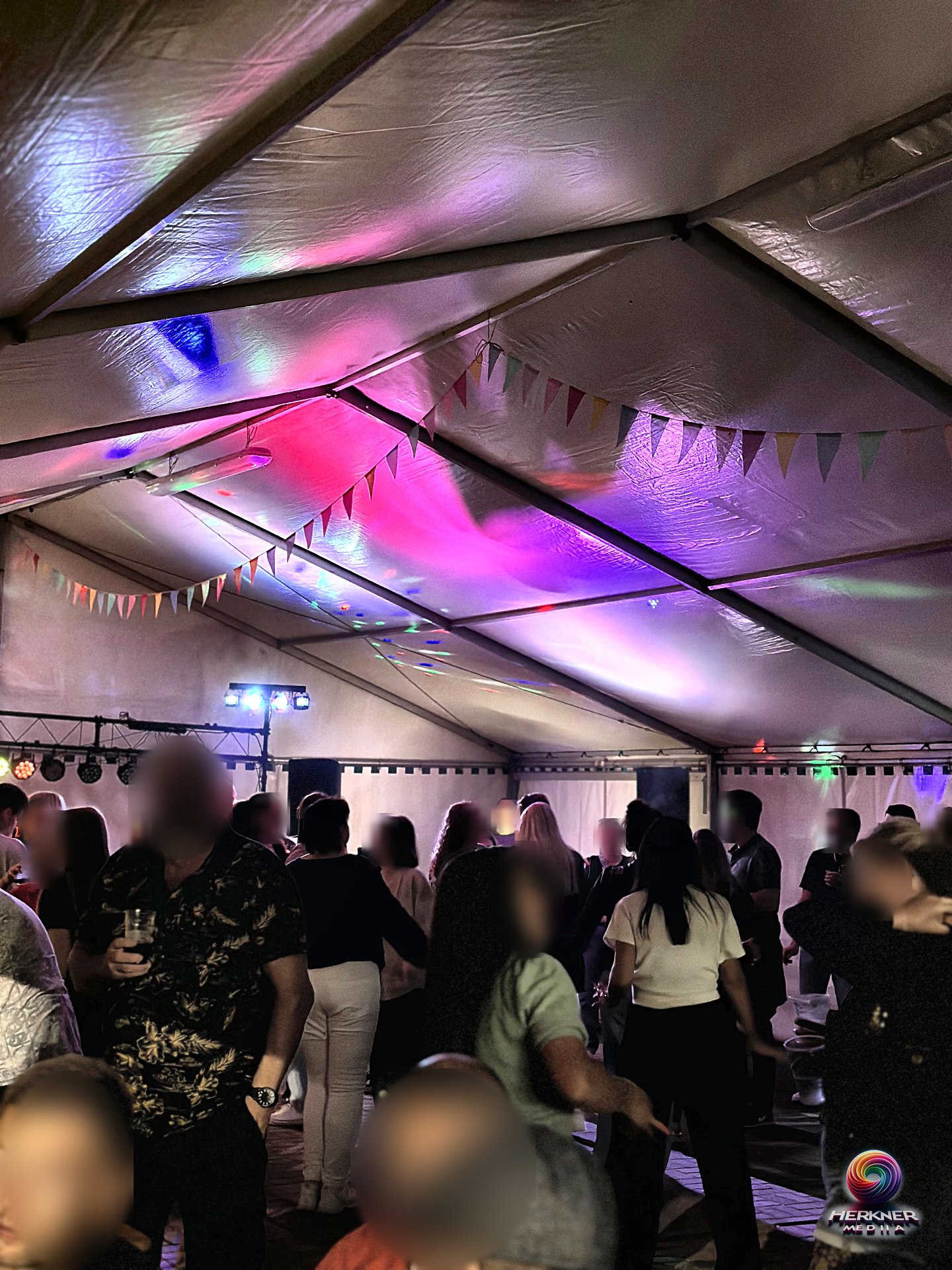 Tanzende Gäste im Partyzelt mit bunter Lichtshow